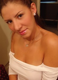 Tara posing in a braless white top